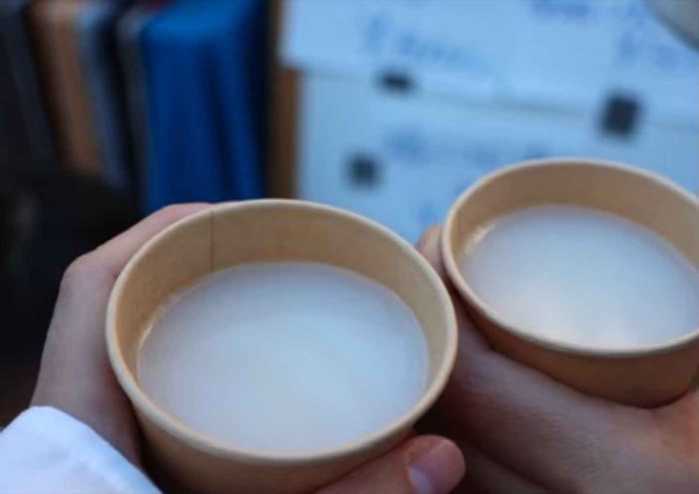 甘酒で乾杯する手元のクローズアップ